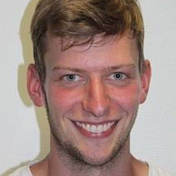 A young man with short, light brown hair smiles at the camera, standing in front of a plain white background—ready to make his mark in MultiStress Research and food security.
